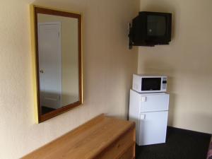 a mirror in a room with a microwave and a refrigerator at Cascade City Center Motel in Lebanon