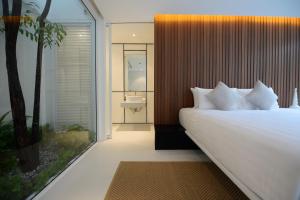 a bedroom with a large white bed and a bathroom at K Maison Lanna Boutique Hotel-SHA Plus Certified in Chiang Mai +73 photos