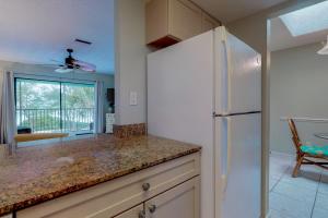 a kitchen with a white refrigerator and a table at Pelican Cove 6 in Bradenton Beach