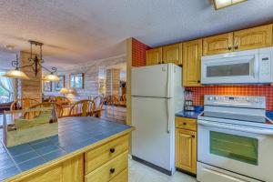 une cuisine avec des appareils électroménagers blancs et des armoires en bois dans l'établissement Snowlake D-25, à Sugar Mountain