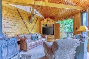 uma sala de estar com um sofá e uma televisão numa cabina em Slopesider 27 em Sugar Mountain