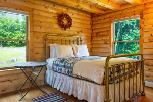een slaapkamer met een bed in een blokhut bij Private Franconia Log Cabin in Franconia