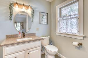a bathroom with a toilet and a sink and a mirror at Hobby Hops Farmhouse in Northport