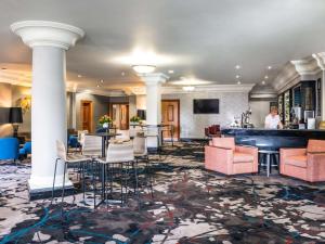 a hotel lobby with a bar and chairs at Mercure Dartford Brands Hatch Hotel & Spa in Ash