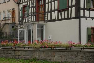 Un bâtiment avec quelques fleurs devant lui dans l'établissement Klosterherberge, à Meßkirch