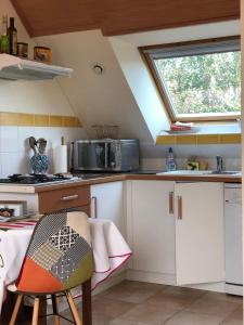een kleine keuken met witte kasten en een raam bij Villanna in Sainte Anne d'Auray 