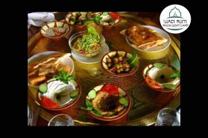 a table with plates of food on top of it at Wadi Rum Moon Light Camp in Wadi Rum