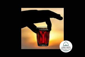 a hand holding a red drink in a glass at Wadi Rum Moon Light Camp in Wadi Rum +49 photos