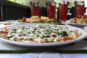 a plate of food on a table with plates of food at Ciudad de Las Rocas in La Fortuna Gallo Giro +59 photos