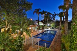 a pool in a resort with palm trees at Mildura Inlander Resort in Mildura