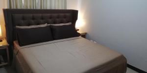 een bed in een kamer met een zwart hoofdeinde bij 101 Newport Boulevard in Manilla