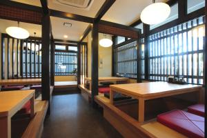 a restaurant with tables and benches and windows at Route Inn Grantia Wakuranoyado Igauenojomae in Iga +34 photos