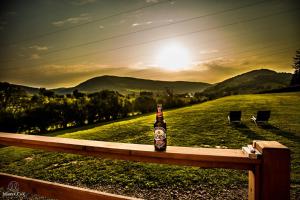 una botella de cerveza sentada en un banco en un campo en KaliMera, en Solina