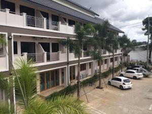 a building with cars parked in a parking lot at Nantawan Hotel in Ban Fang Min
