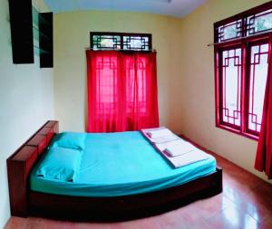 a bedroom with a bed with a red window at Resort Highlander in Bogor