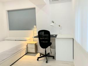 1 dormitorio con escritorio, 1 cama y 1 silla en Hispania House, en Huelva