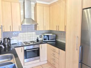 a kitchen with a stove top oven and a microwave at De Waterkant Piazza Apartments in Cape Town
