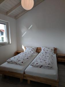 2 Betten in einem kleinen Zimmer mit Fenster in der Unterkunft Haus Märzenbach in Kaufbeuren