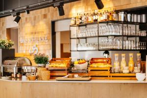 a restaurant with a counter with food on it at Das Schierke Harzresort in Schierke