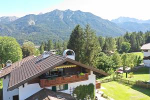 a house with a balcony with mountains in the background at Bergleben in Krün