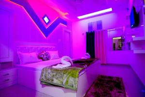 a pink bedroom with a bed with swans on it at Taj Square A luxurious family homestay in Agra