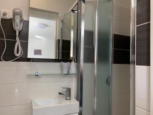 a bathroom with a sink and a shower at Mikulov Inn - Apartments Slunce in Mikulov