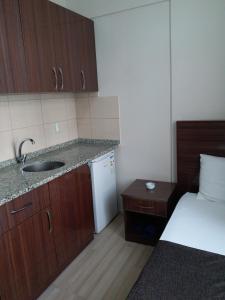 eine kleine Küche mit einem Waschbecken und einem Bett in der Unterkunft OTEL SERKAN in Isparta