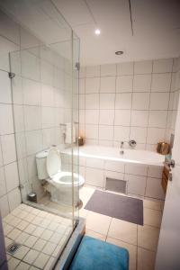 a bathroom with a toilet and a glass shower at Stay at The Point- Happy Homely Horizons in Durban