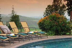 a group of chairs sitting next to a swimming pool at Premier Hotel The Winkler in White River