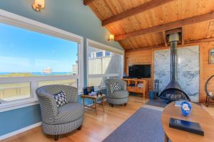 a living room with two chairs and a fireplace at Ocean's Reach in Pacific City