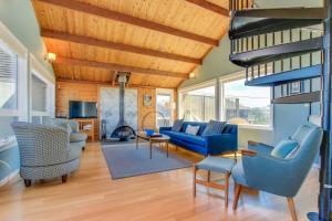 a living room with blue chairs and a fireplace at Ocean's Reach in Pacific City