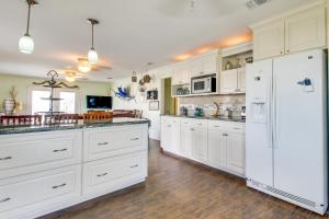 a kitchen with white cabinets and a white refrigerator at Mesquite House Upstairs Unit in South Padre Island