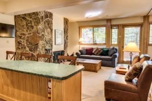 a living room with a stone wall at Cozy Slopeside Condo in Snowmass Village