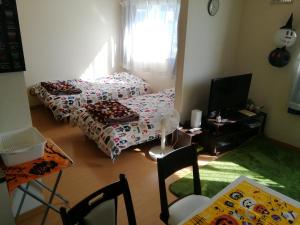 ein Wohnzimmer mit 2 Betten und einem TV in der Unterkunft Hakodate station 5minutes walk vacation stay in Hakodate
