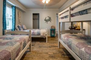 two bunk beds in a room with wooden floors at Mesquite House Downstairs Unit in South Padre Island