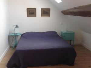 - une chambre avec un lit violet et une table bleue dans l'établissement Au Pied des Vignes, à Santenay