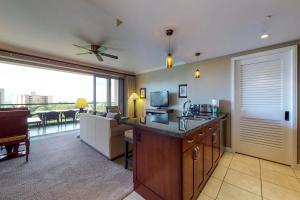 a living room with a kitchen with a couch and a television at Honua Kai - Konea 738 in Lahaina