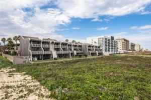 a building on the beach with a grass field at Beachview Condominiums: #204 in South Padre Island