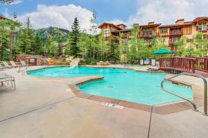 a pool at a resort with chairs and trees at Eagle Springs East 206: White Fir Suite in Solitude