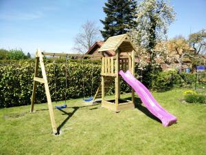un parque infantil con tobogán y estructura de juegos en Fewo-Seefeld, en Norderaussendeich