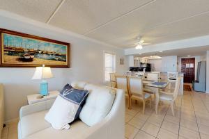 a living room with a white couch and a dining room at Beachview Condominiums: #204 in South Padre Island