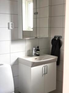 a bathroom with a white sink and a mirror at Superfint boende med havsutsikt, Tofta Strand in Visby