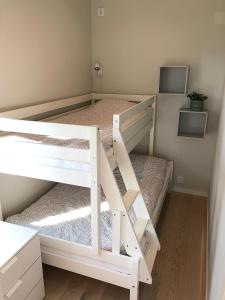 a white bunk bed in a small room at Superfint boende med havsutsikt, Tofta Strand in Visby