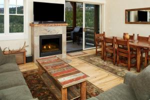 a living room with a fireplace and a table and chairs at Saddle Ridge Townhome G-2 in Big Sky