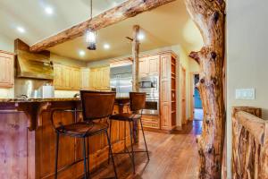 une cuisine avec des placards en bois et un bar avec des tabourets dans l'établissement Moose Jaw Retreat, à Vista