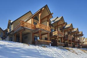 a large wooden house on top of a snowy hill at Saddle Ridge Townhome G-2 in Big Sky