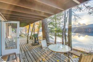 a porch with a table and chairs and a view of a lake at Bay Point Lakefront 4A Down in Whitefish