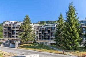 an apartment building with trees in front of a road at Résidence Pierre & Vacances La Forêt in Flaine