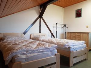 uma cama grande num quarto com tecto em madeira em Penzion Cerhenice em Cerhenice