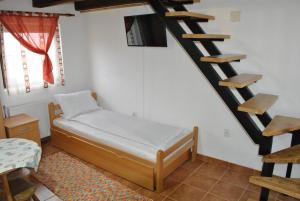 um pequeno quarto com uma cama e uma escada em Etno selo Lelić em Valjevo